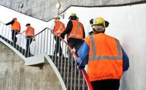 Workers putting on protection equipment ascending a staircase in a hydropower place